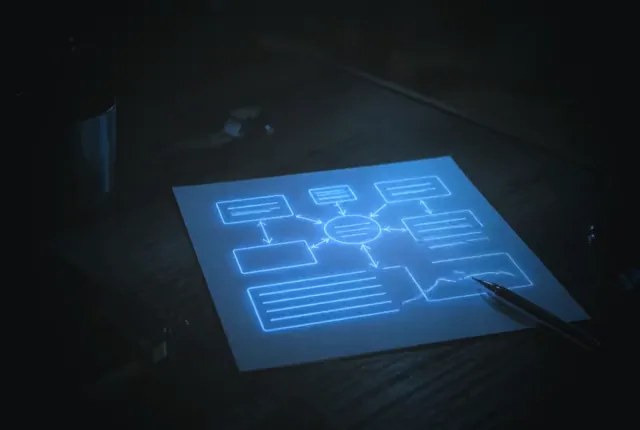 A one-page plan on a dark desk, its diagram glowing softly, a pen waiting beside it